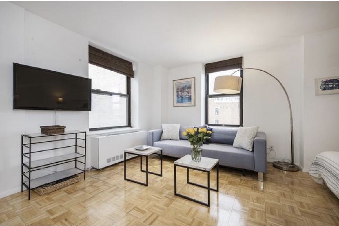 201 West 74th Street, Unit 16A Manhattan, NY 10023 - Photo 2 of 13 a living room with furniture and a flat screen tv