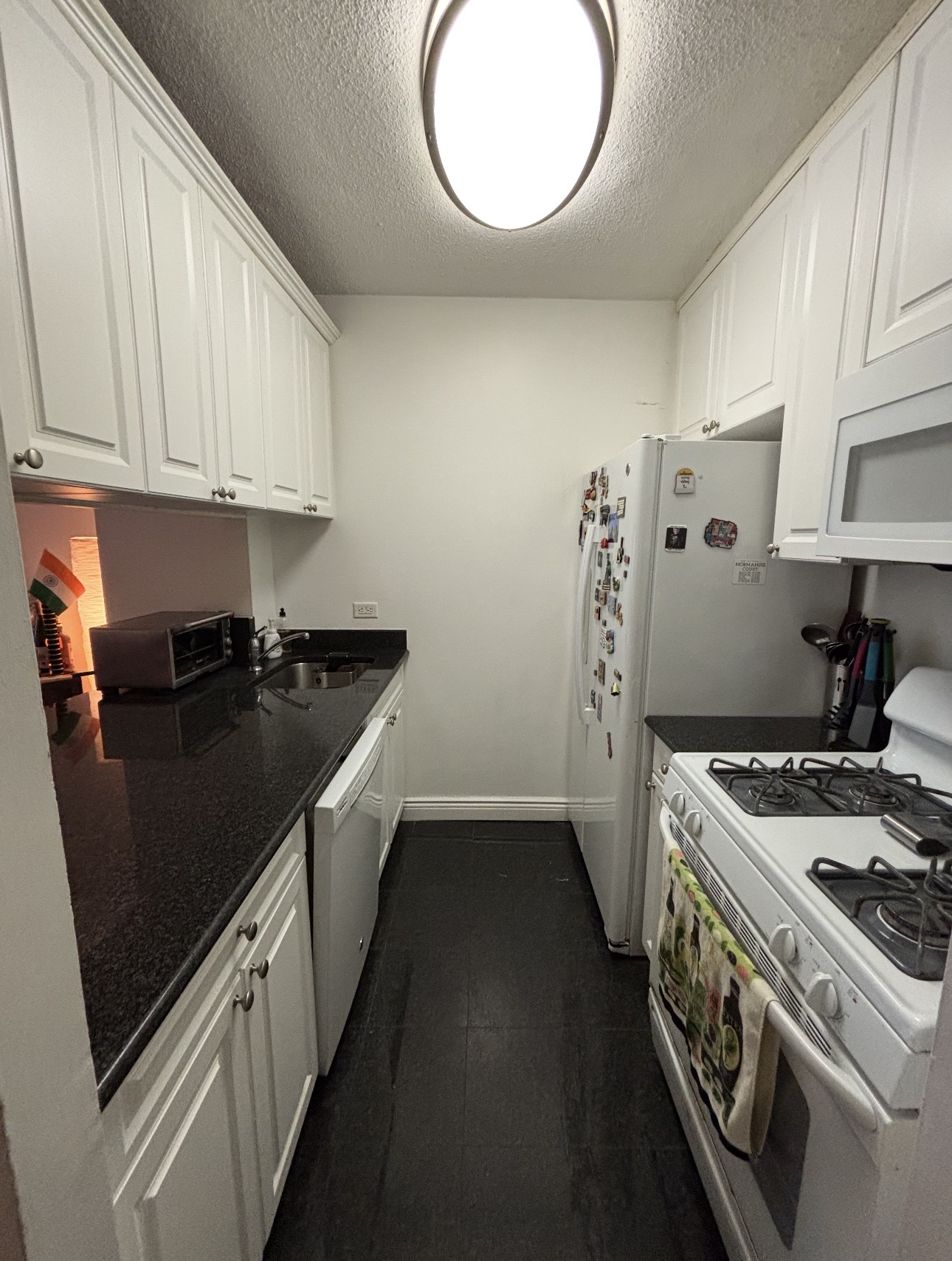 215 East 95th Street, Unit 19G Manhattan, NY 10128 - Photo 4 of 14 a kitchen with a stove sink and cabinets