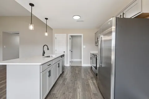 a kitchen with stainless steel appliances a sink stove and refrigerator