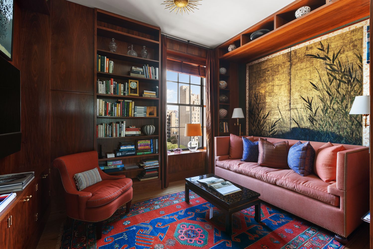 a living room with furniture a bookshelf and a window