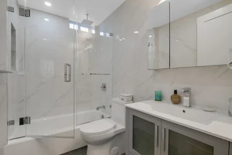 a bathroom with a sink a toilet and shower