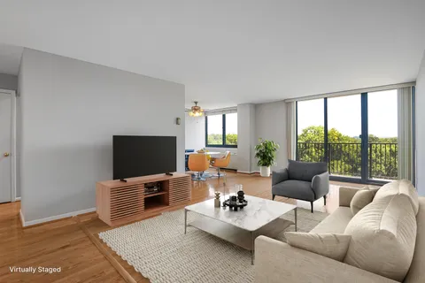 a living room with furniture a flat screen tv and a floor to ceiling window