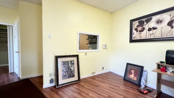 a view of a hallway with wooden floor and closet