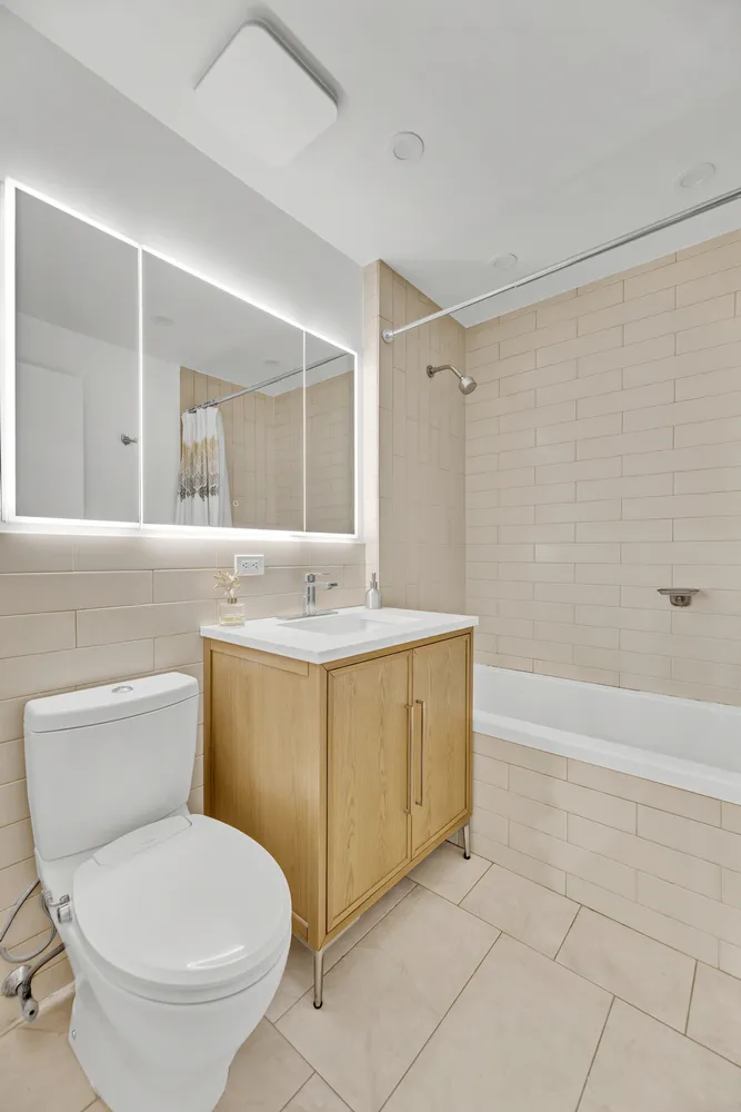 a bathroom with a toilet sink and mirror