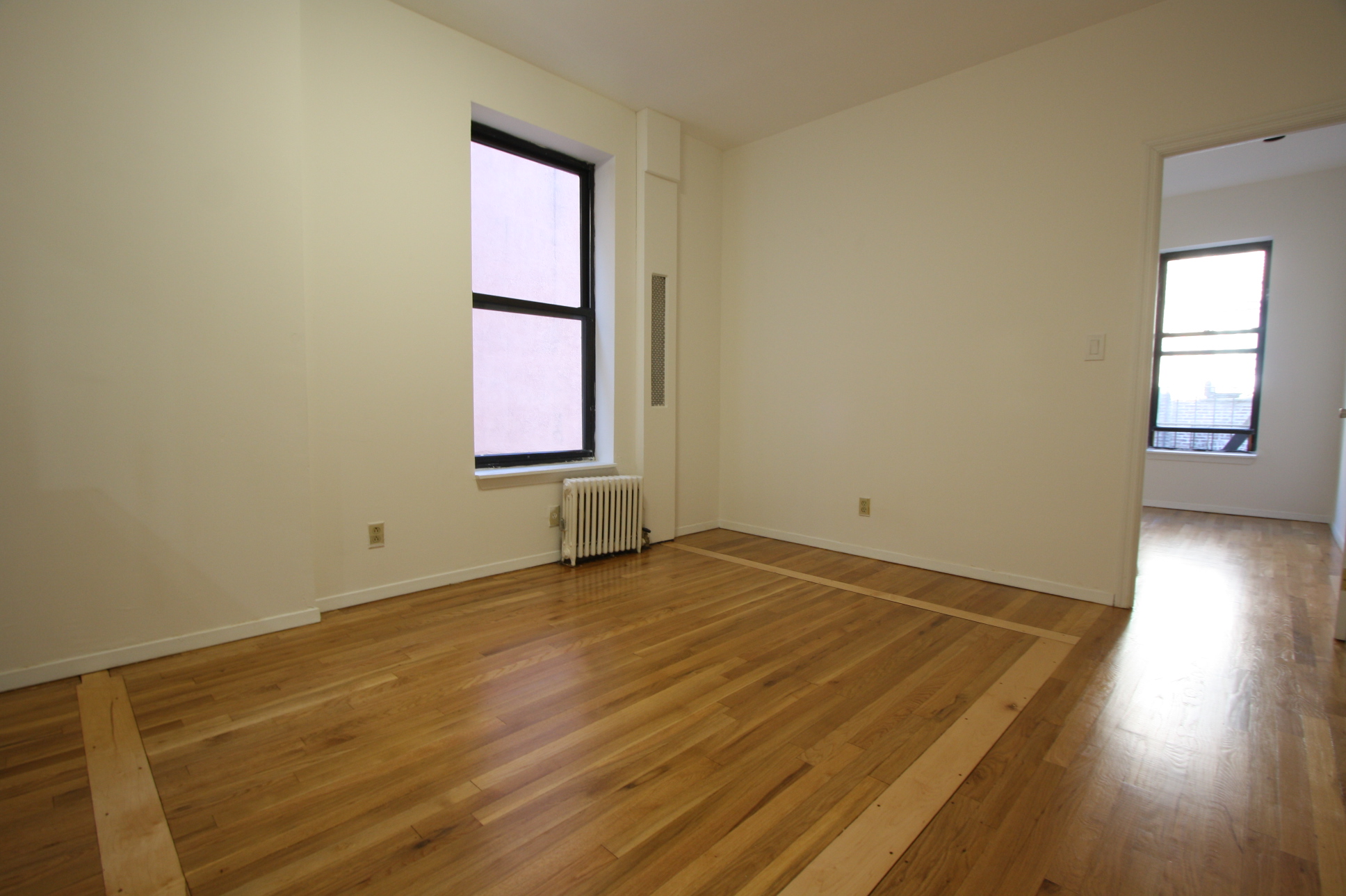 435 East 75th Street, Unit 13 Manhattan, NY 10021 - Photo 1 of 6 an empty room with wooden floor and windows