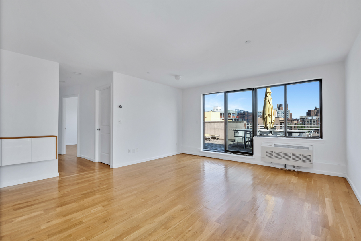 416 East 117th Street, Unit PH6 Manhattan, NY 10035 - Photo 10 of 20 a view of empty room with wooden floor and fireplace
