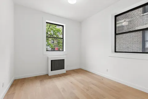 an empty room with window and fireplace