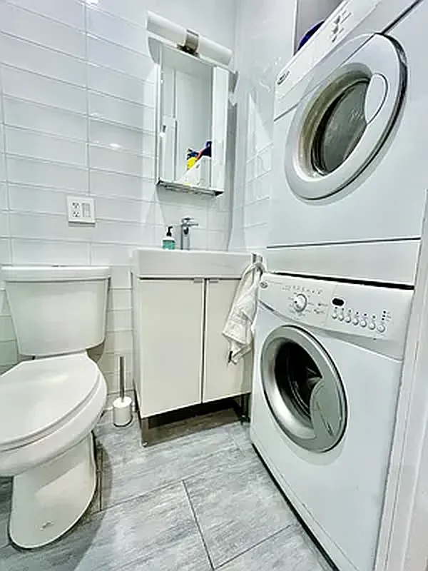 57 Spring Street, Unit 2 Manhattan, NY 10012 - Photo 4 of 5 a utility room with dryer and washer