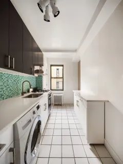 a kitchen with a sink a stove cabinets and utility room