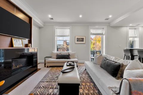 a living room with furniture a flat screen tv and a fireplace
