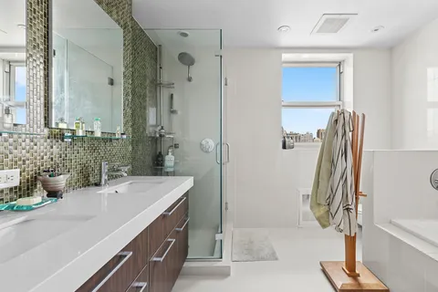 a bathroom with a double vanity sink a mirror and a shower