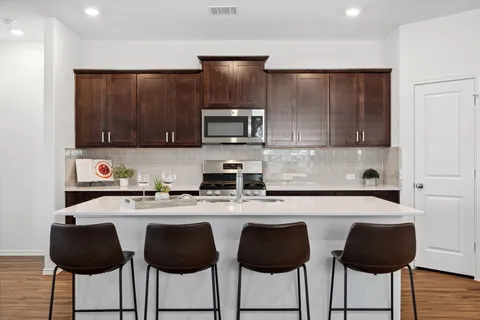 a kitchen with granite countertop a stove a sink and a microwave