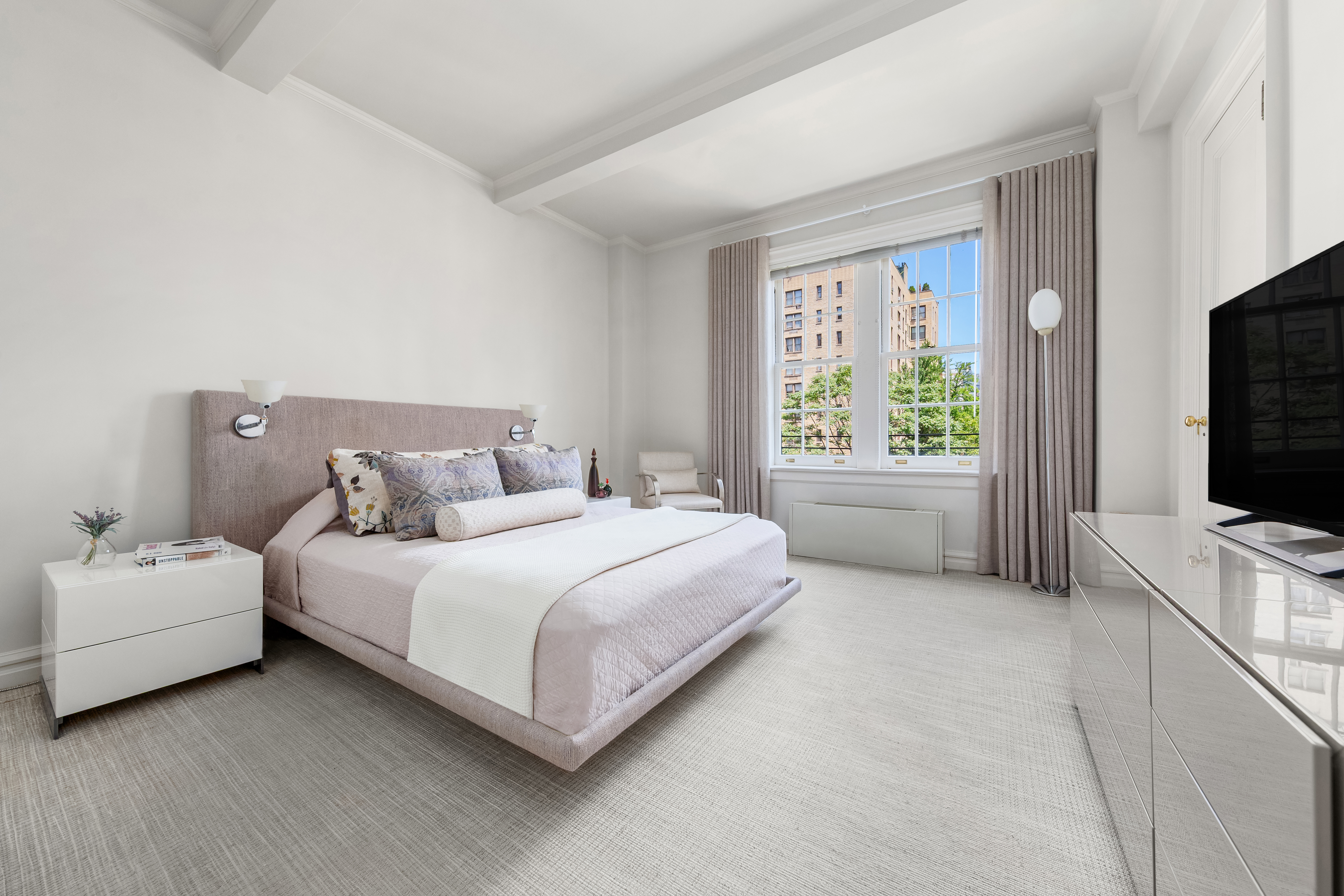 162 East 80th Street Manhattan, NY 10075 - Photo 7 of 13 a spacious bedroom with a bed and a flat screen tv