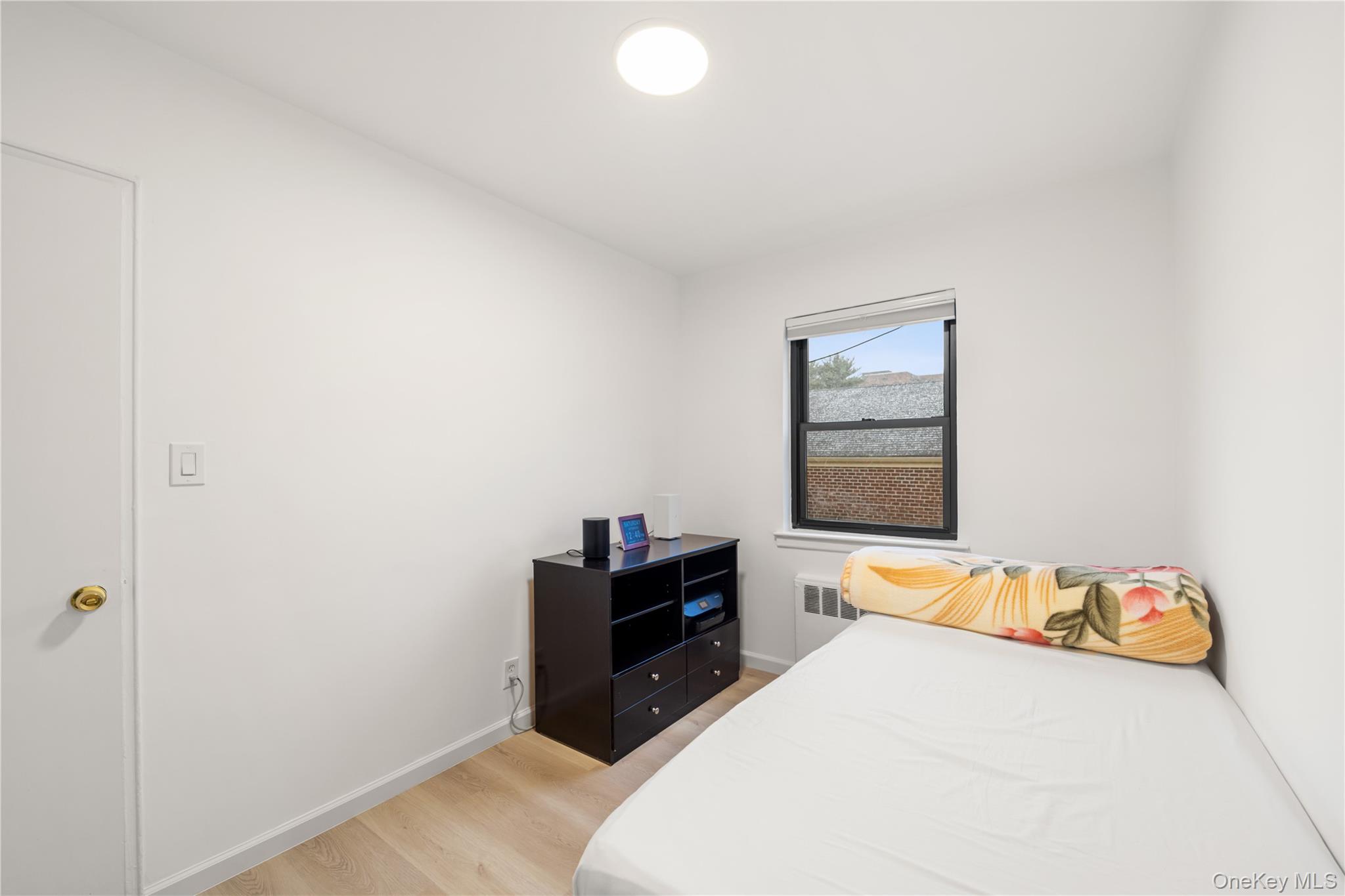 217-14 73rd Avenue, Unit 1 Queens, NY 11364 - Photo 15 of 19 a bedroom with a bed and a window