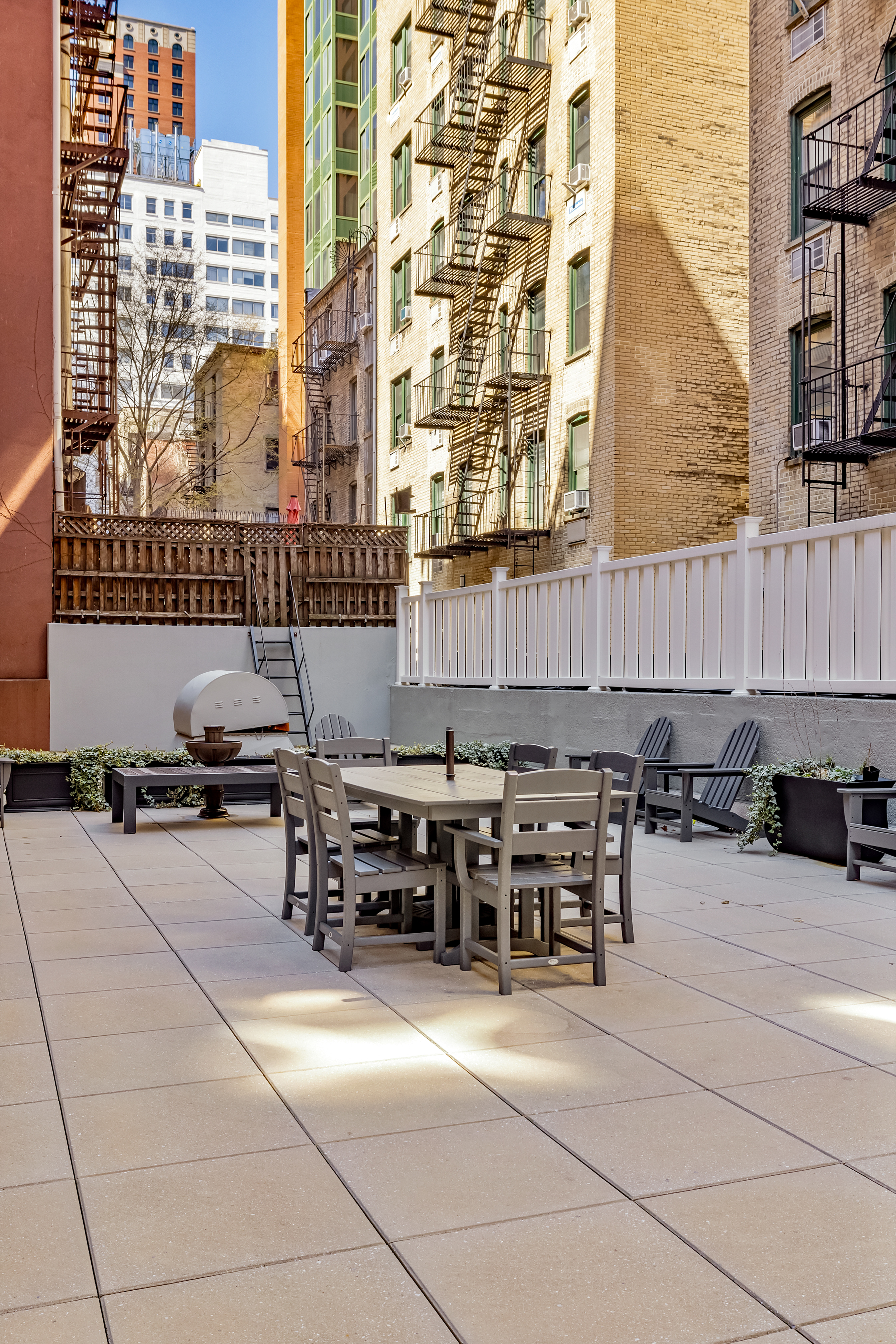 233 East 69th Street, Unit 2C Manhattan, NY 10021 - Photo 7 of 10 a backyard of a building with barbeque oven and outdoor seating