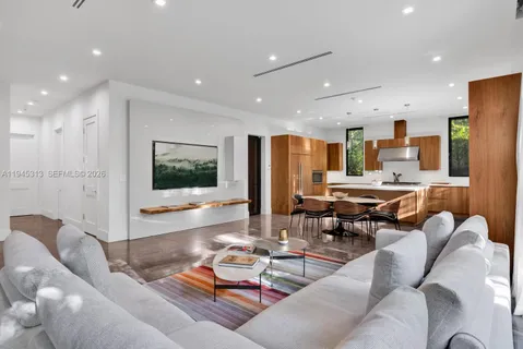 a living room with lots of furniture and view of kitchen