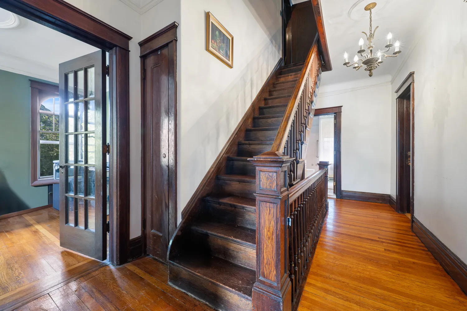 a view of a hallway with wooden floor and staircase