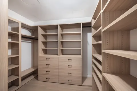 a view of walk in closet with empty racks