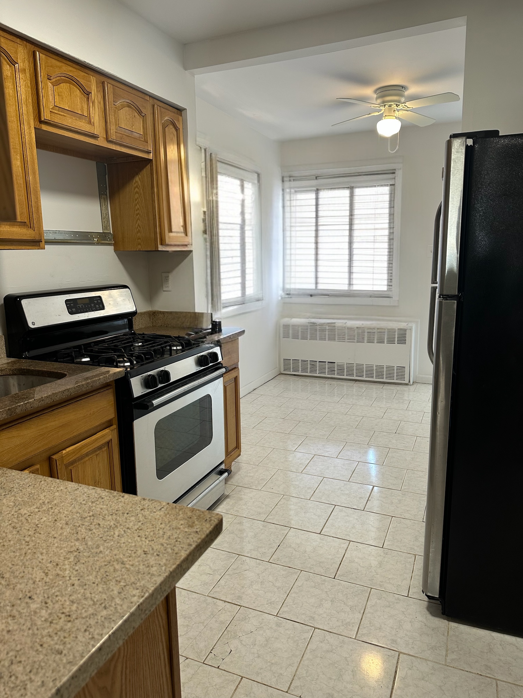 9823 Seaview Avenue, Unit 1 Brooklyn, NY 11236 - Photo 2 of 3 a kitchen with granite countertop a stove and a refrigerator