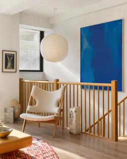 a living room with a couch and paintings on the wall