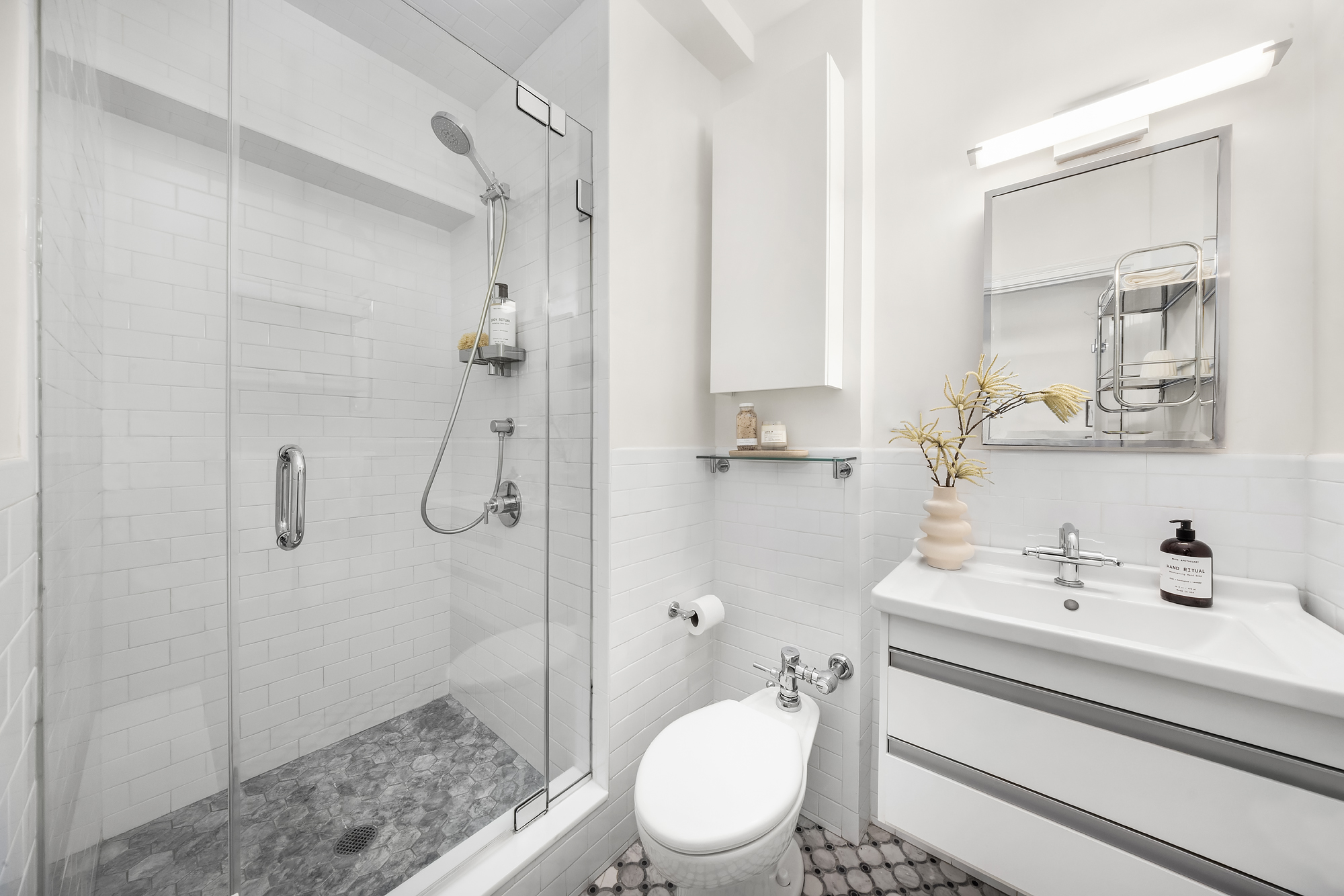 49 East 96th Street, Unit 9B Manhattan, NY 10128 - Photo 11 of 15 a bathroom with a sink toilet and shower