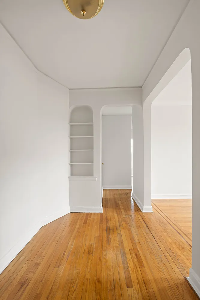 an empty room with wooden floor and closet