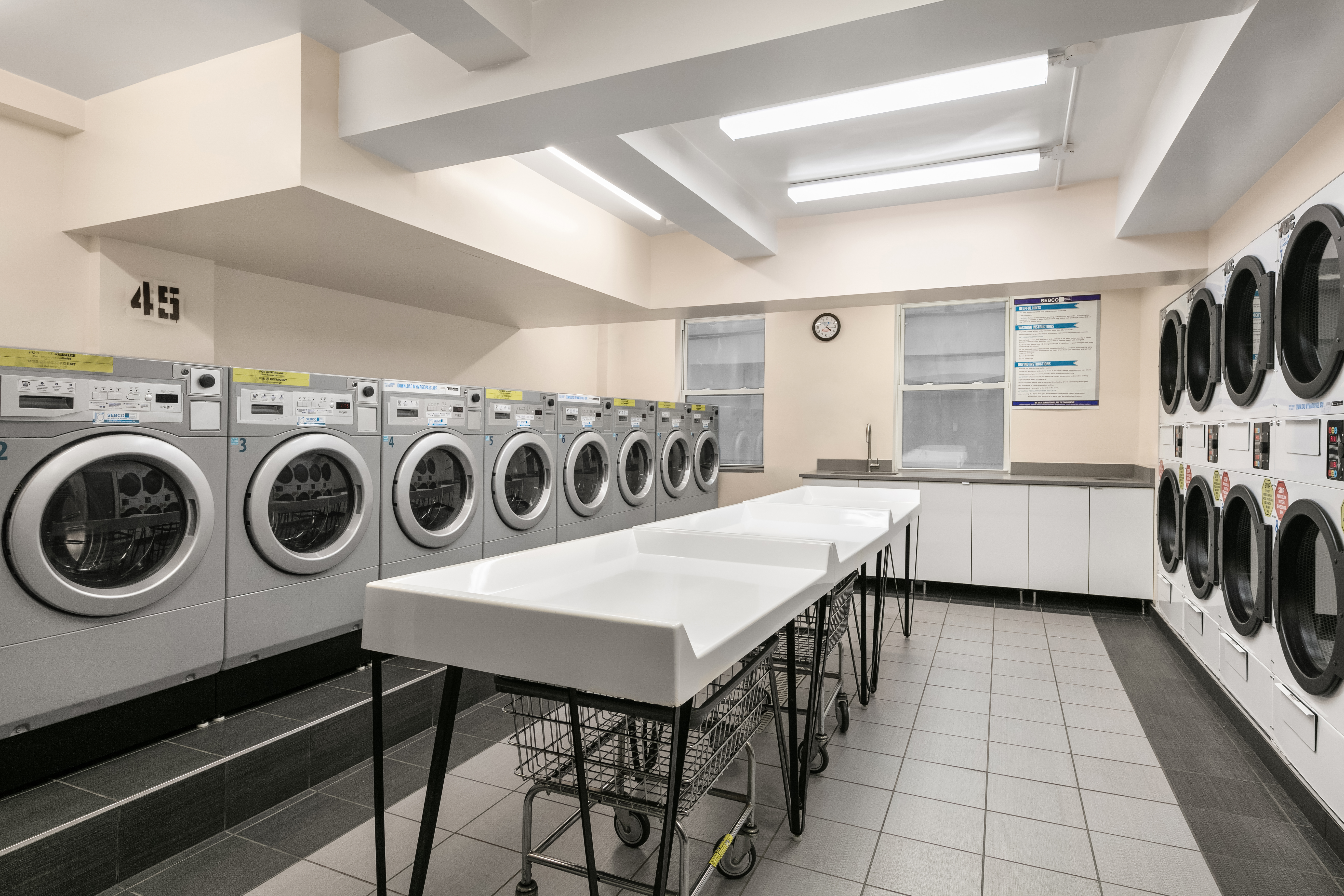 333 East 43rd Street, Unit 709 Manhattan, NY 10017 - Photo 14 of 15 a utility room with dryer washer and a view of living room