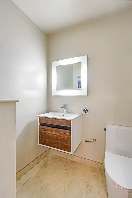 32 East 76th Street, Unit 502 Manhattan, NY 10021 - Photo 6 of 7 a bathroom with a toilet a sink and mirror