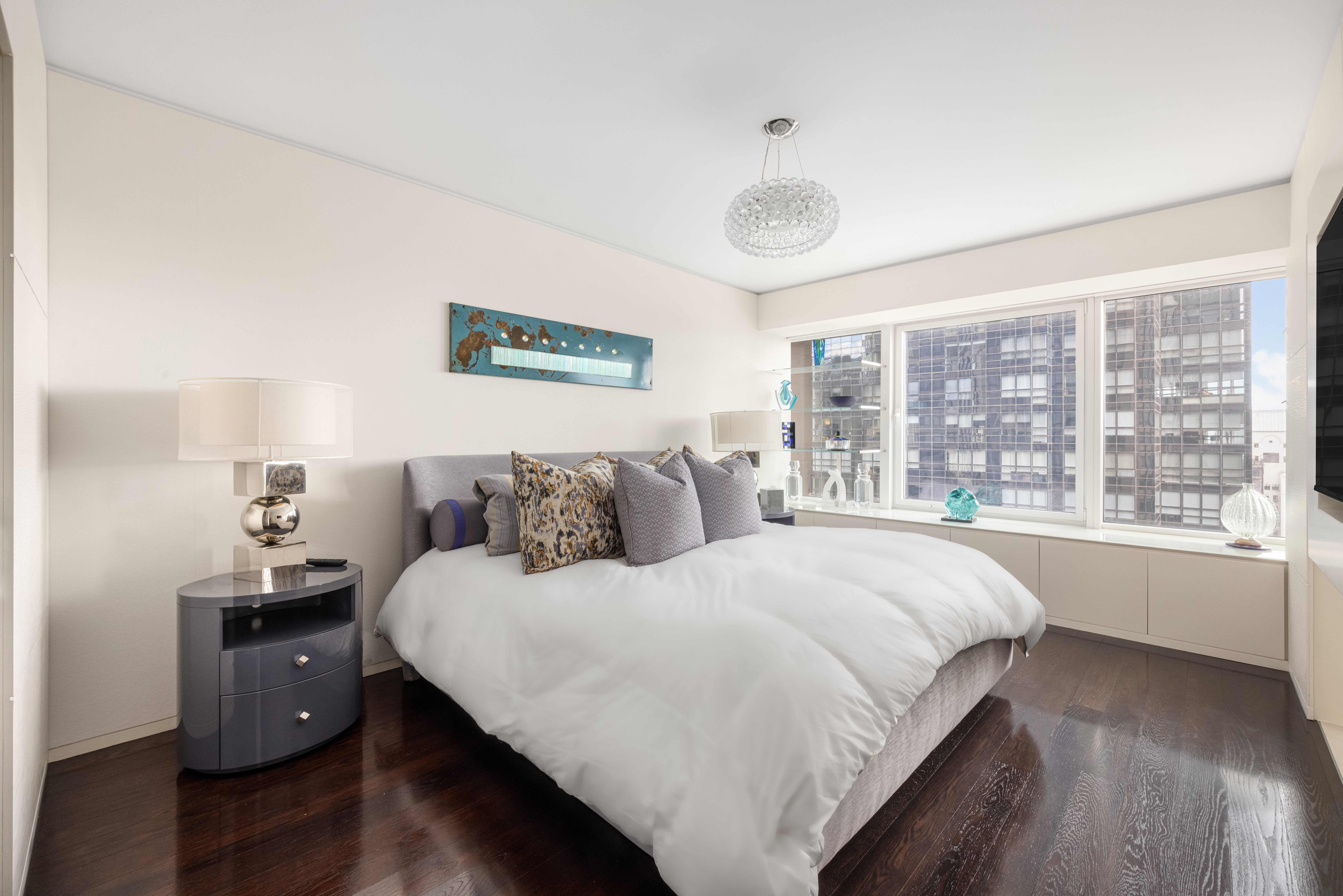 150 West 56th Street, Unit 3901 Manhattan, NY 10019 - Photo 8 of 25 a large bed sitting in a bedroom next to a large window