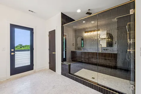 a bathroom with a glass shower door and a mirror