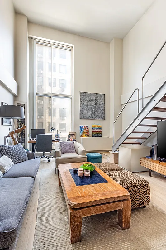 32 East 76th Street, Unit 502 Manhattan, NY 10021 - Photo 3 of 7 a living room with furniture a rug and a table
