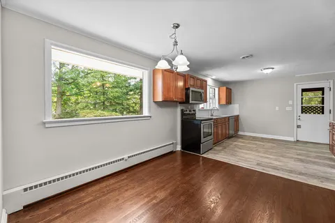 a kitchen with granite countertop wooden floors and wide window