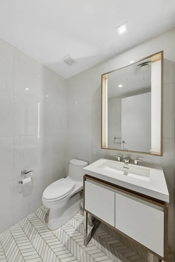 a bathroom with a sink toilet and mirror