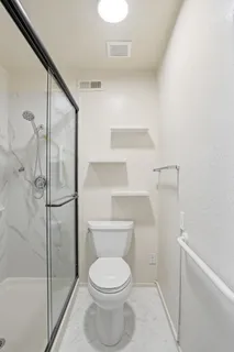 a bathroom with a toilet and a shower