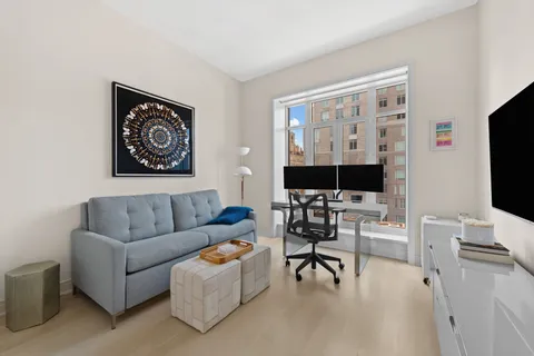 a living room with furniture a flat screen tv and a large window