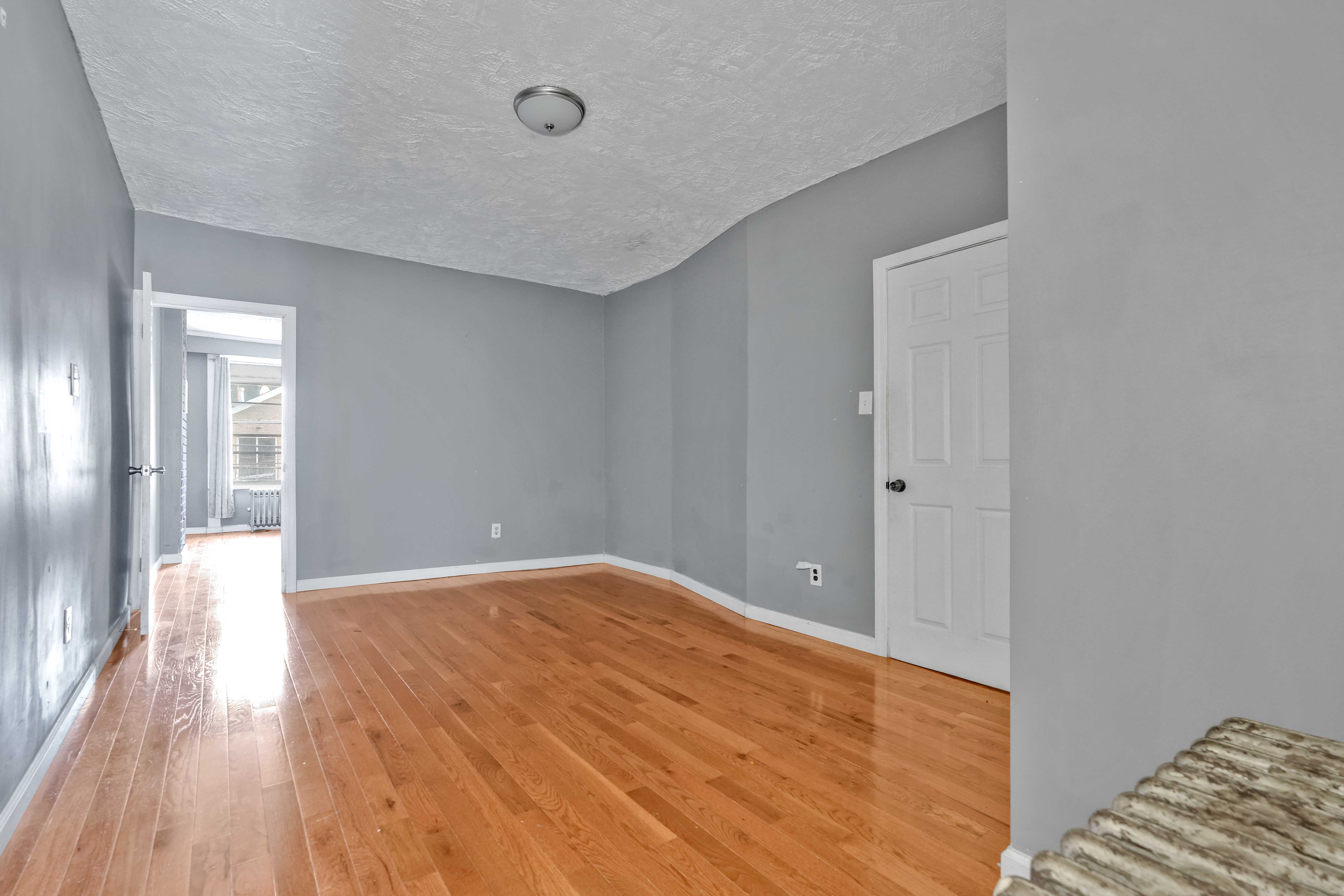 610 Ashford Street Brooklyn, NY 11207 - Photo 6 of 28 a view of empty room with wooden floor