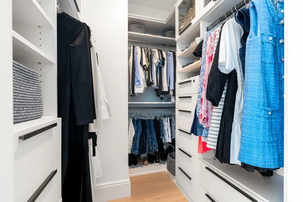 a view of walk in closet with clothes and shoes