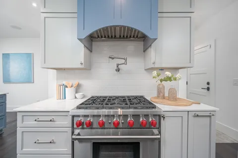 a kitchen with white cabinets and a window