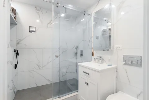 a bathroom with a sink a toilet and shower