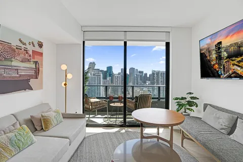 a living room with furniture and a floor to ceiling window