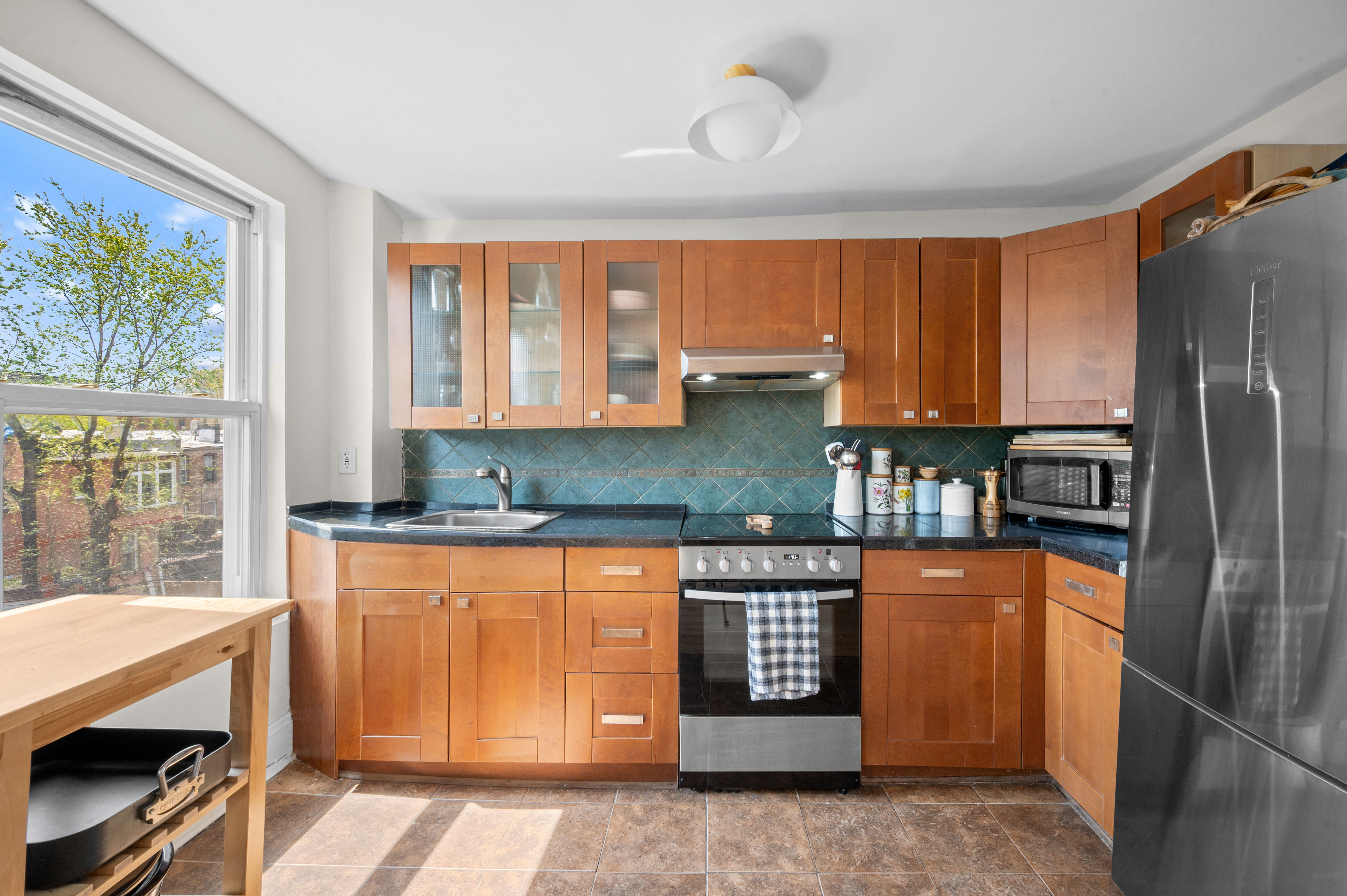 204 Madison Street, Unit 3 Brooklyn, NY 11216 - Photo 5 of 5 a kitchen with stainless steel appliances granite countertop a refrigerator and a sink