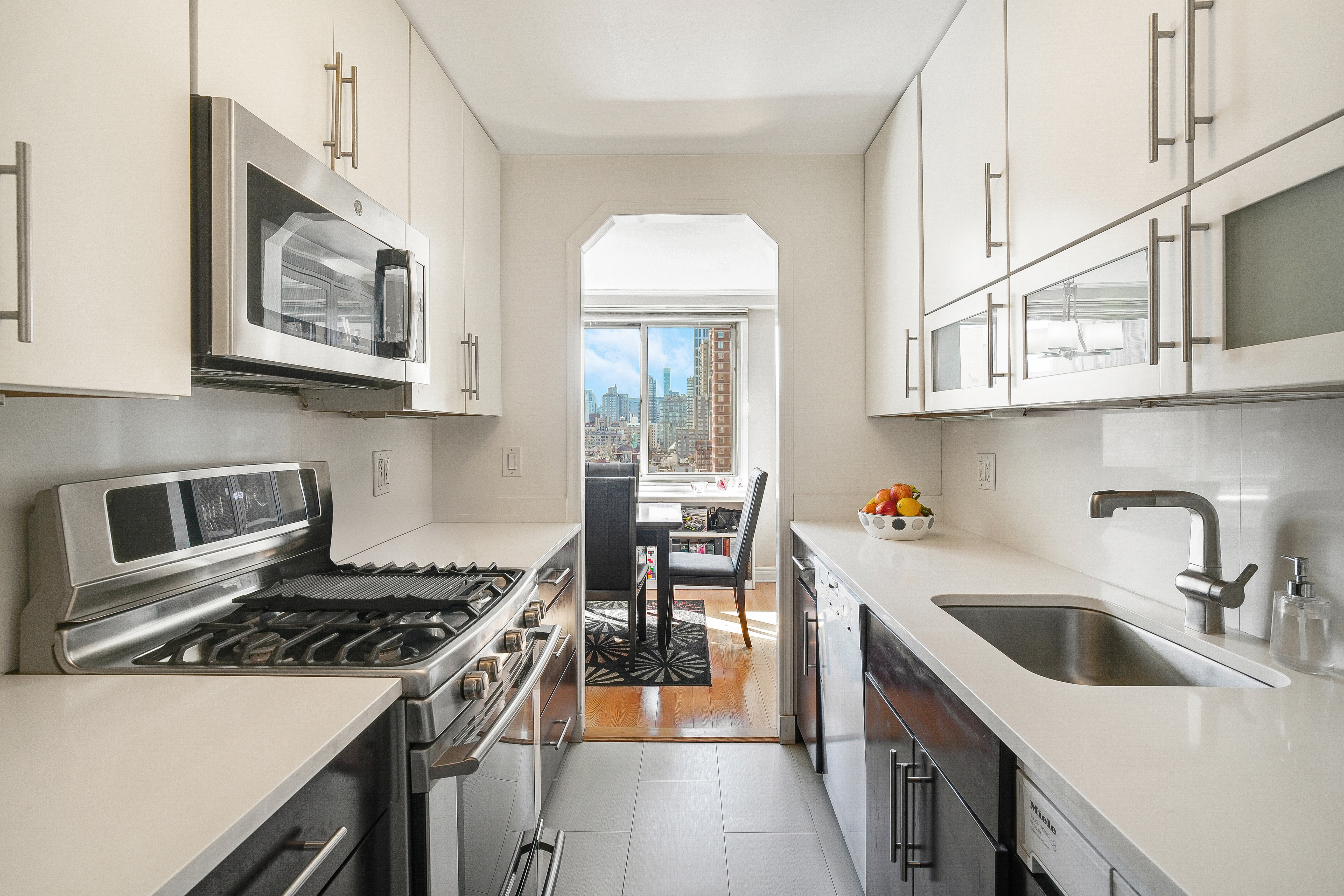 401 East 86th Street, Unit 15C Manhattan, NY 10028 - Photo 3 of 14 a kitchen with stainless steel appliances granite countertop a stove a sink and a microwave