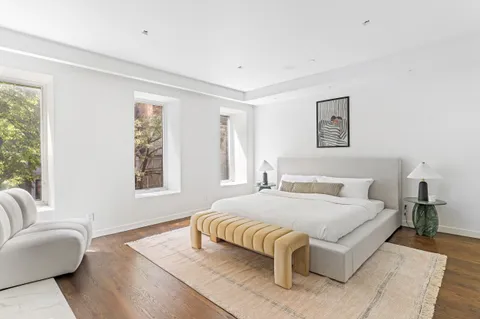 a bedroom with a bed couch and a large window