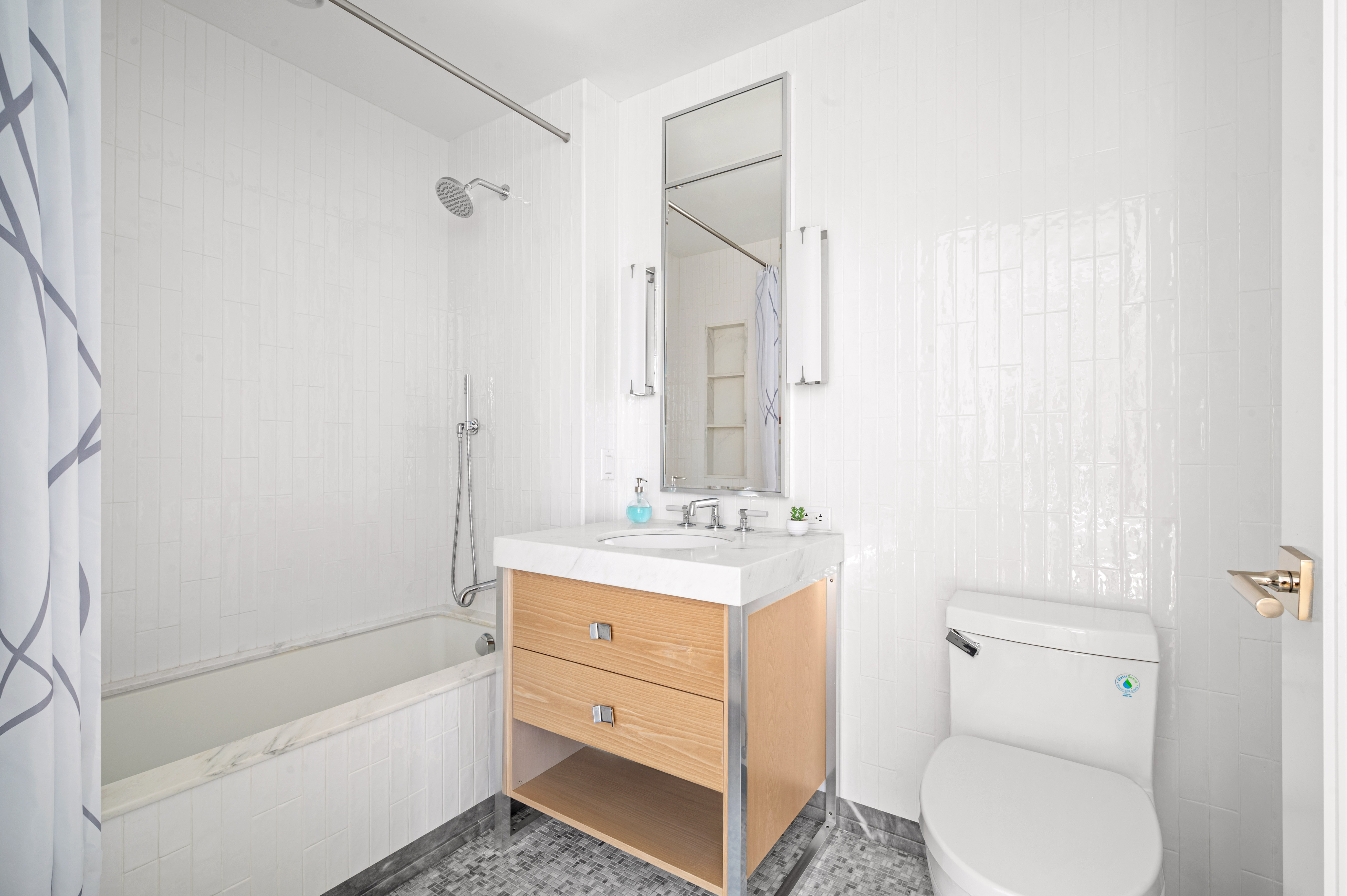 368 3rd Avenue, Unit 11AA Manhattan, NY 10016 - Photo 11 of 18 a bathroom with a granite countertop toilet a sink and a bathtub