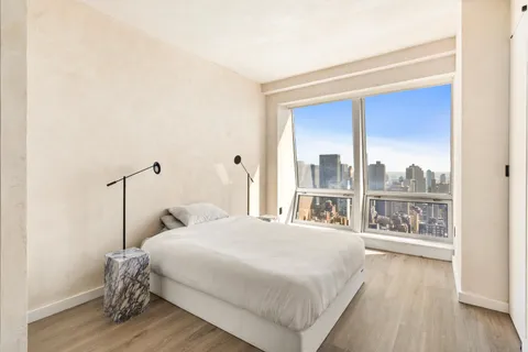 a bedroom with a bed and a large window