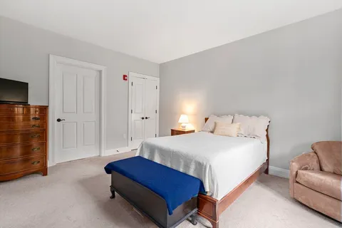 a spacious bedroom with a bed and cabinet