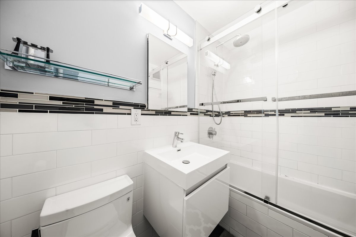 350 Ocean Parkway, Unit 3C Brooklyn, NY 11218 - Photo 8 of 10 a bathroom with a sink a mirror and a toilet