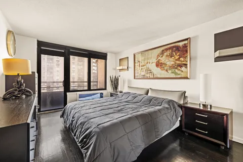 a bed sitting in a bedroom next to a window