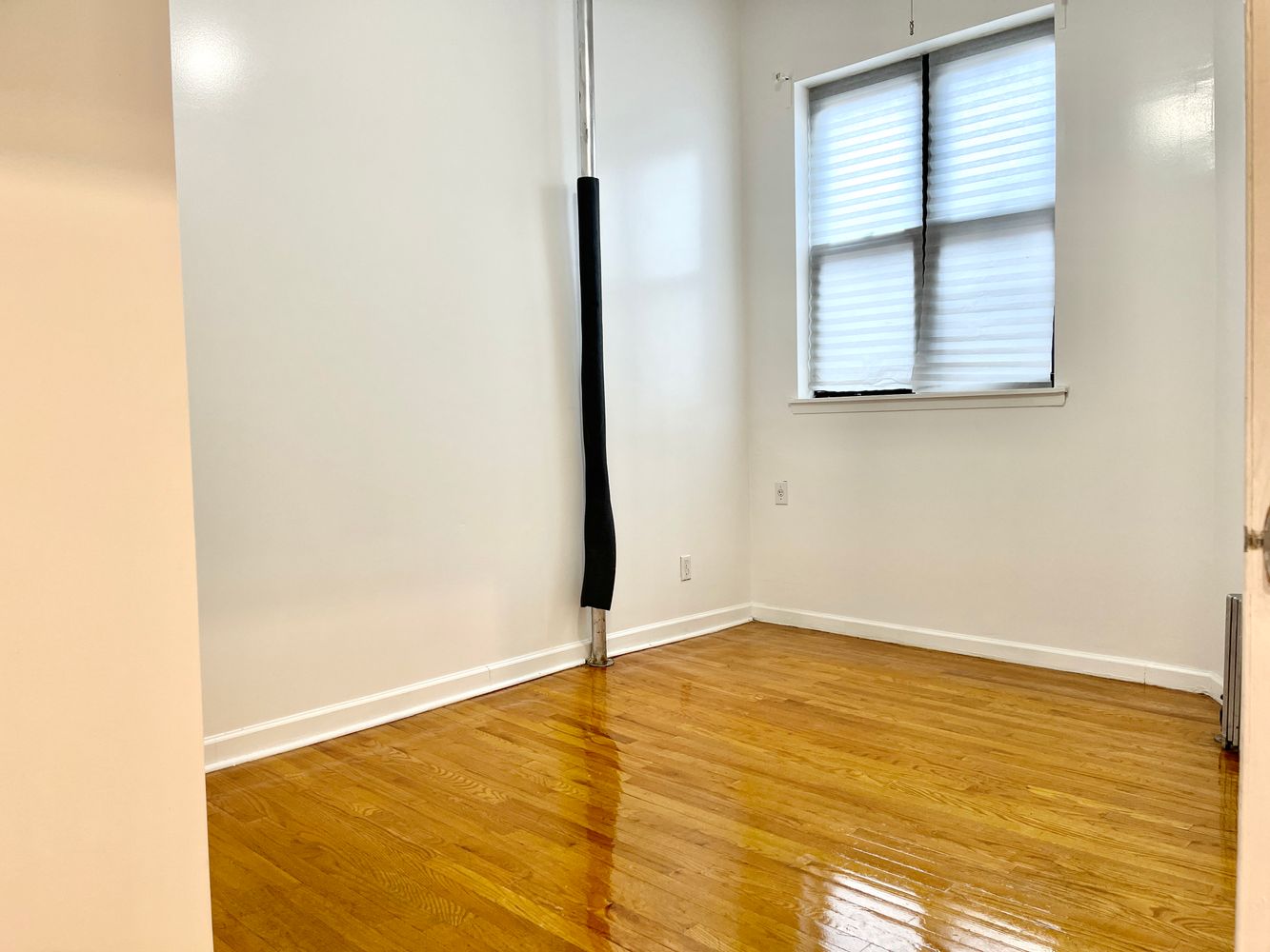 1672 Park Avenue Manhattan, NY 10035 - Photo 11 of 35 a view of an empty room with wooden floor and a window