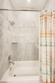 a bathroom with a shower and a bath tub